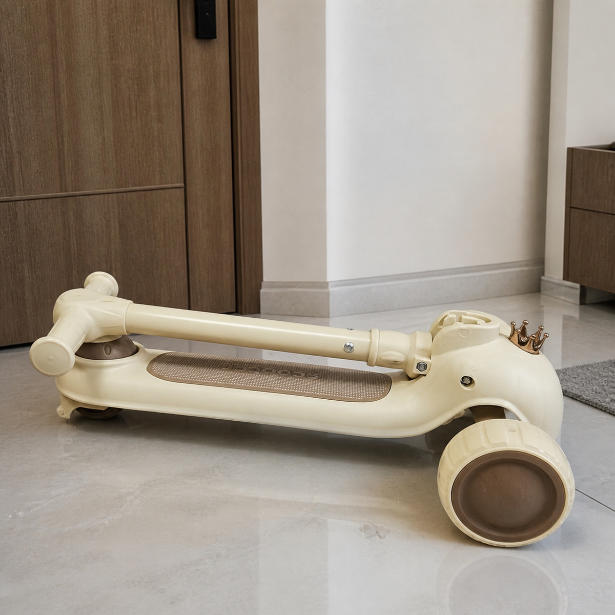 Scooter infantil beige plegado con tubo paralelo a la tabla